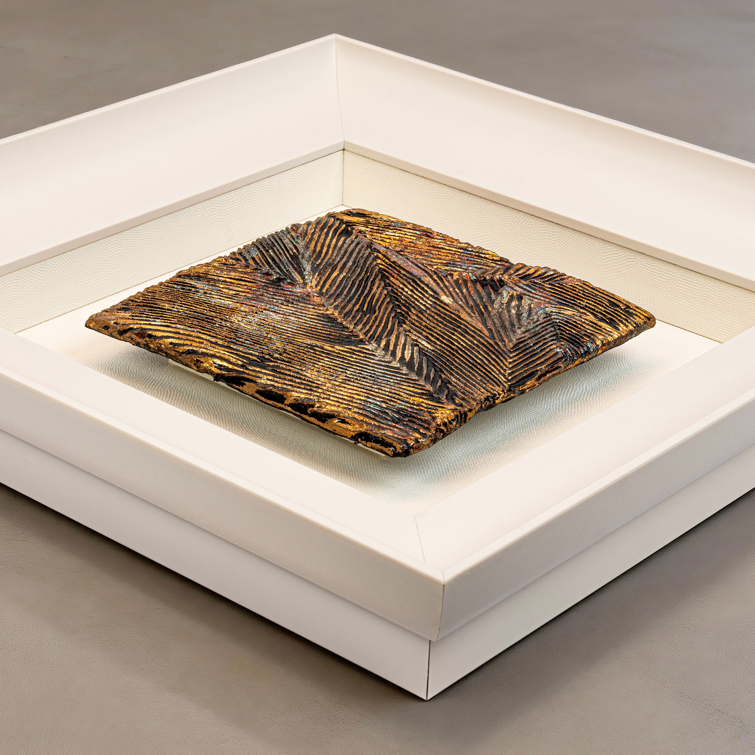 Flat-lay overhead view of Striae — Patinated Foil · Aura Frame, capturing the full expanse of its 3D metal element mineral surface — directional crackle fissures and metallic foil striations running in parallel across the rough, mottled terrain of fractured earth and fired ore.