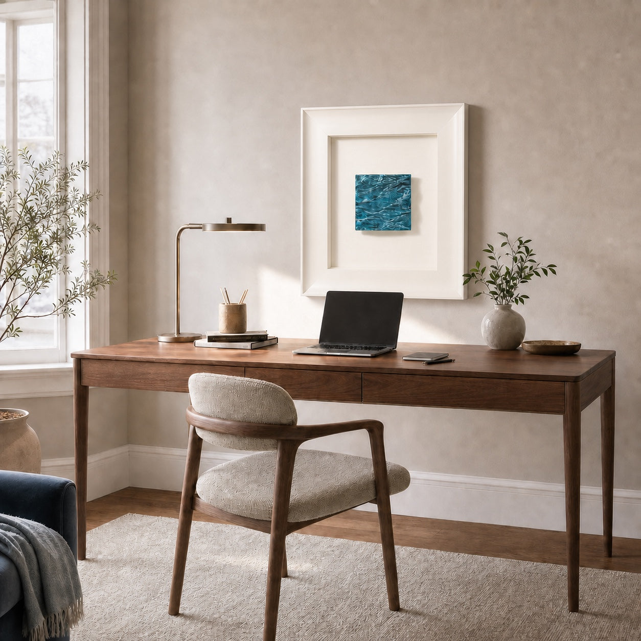 Pelagic Aura Frame shown at its 45 by 45 cm scale above a 140 cm walnut desk
